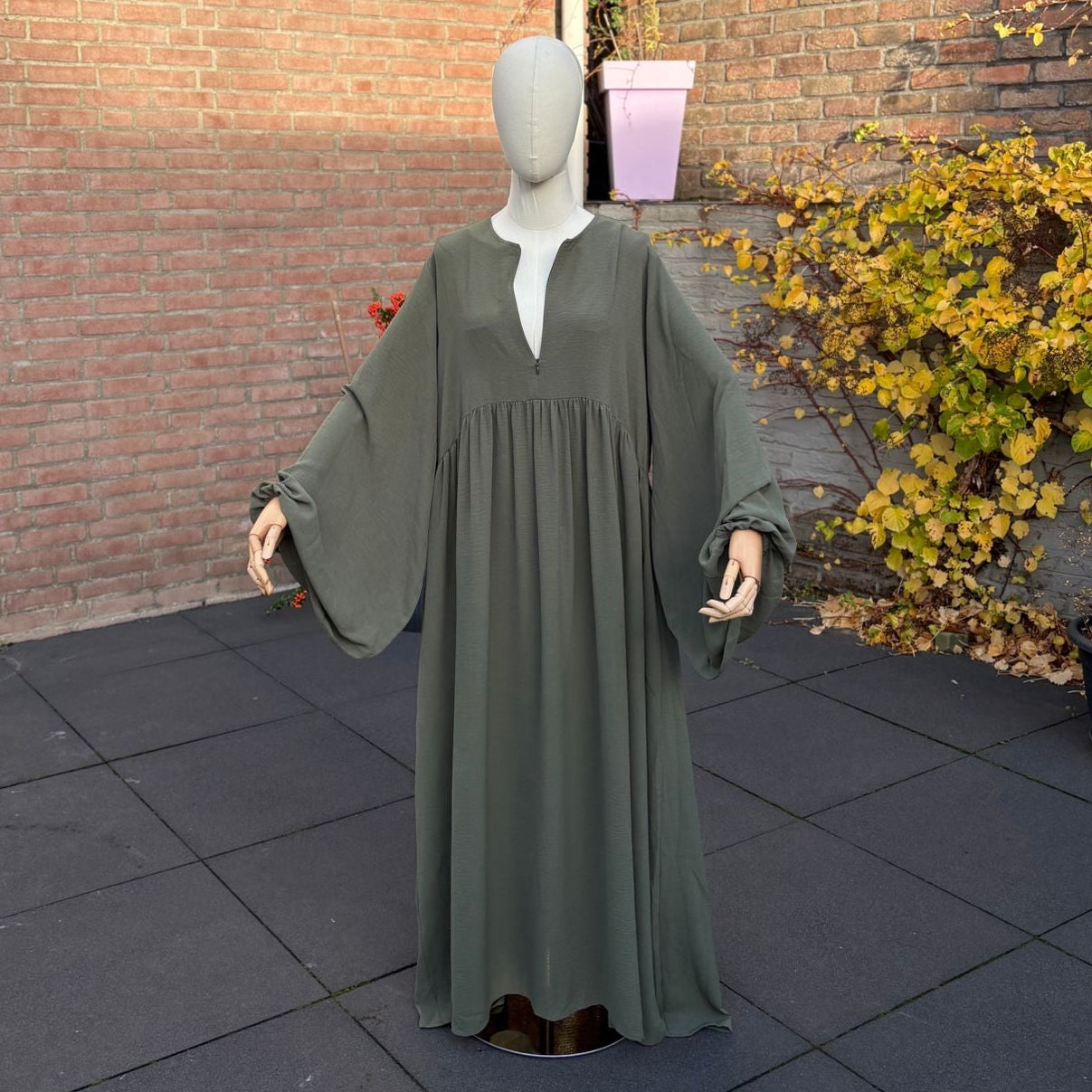 Abaya Maryam Sage Green — empire-lijn met rimpels, wijde bell-sleeves, V-opening, maxi-lengte.