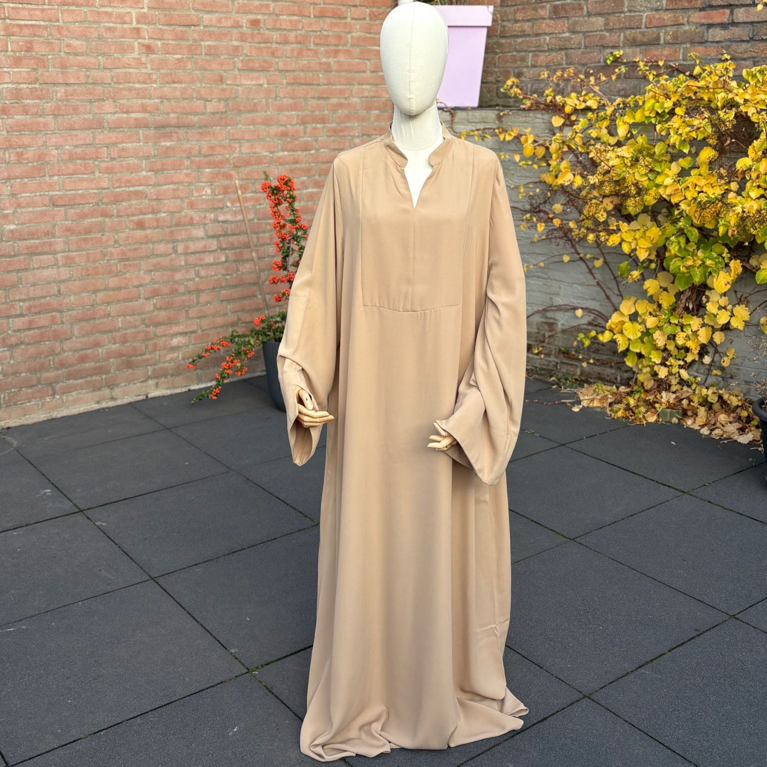 Abaya Sand — bandkraag met V-opening, wijde mouwen, maxi-lengte.